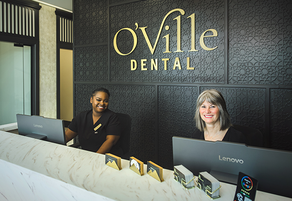 A happy couple sitting in a waiting area, looking at a magazine. Visit a dentist in Orangeville, Ontario, for quality dental care.