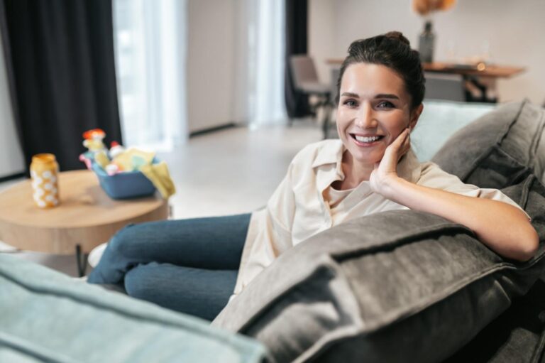 Woman smiling while resting on a sofa